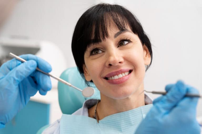 Femeie zambitoare, la dentist, dupa ce a ales cel mai bun implant dentar