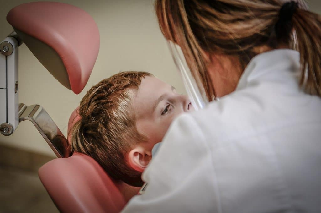 Frenectomia asistată de laser este realizată mai precis, mai rapid, iar disconfortul este redus la maximum Baietel pe scaunul dentistului, la tratament pentru frenectomie
