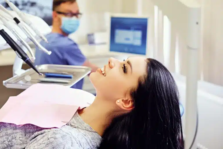 Femeie la dentist si medic in fata monitoarelor