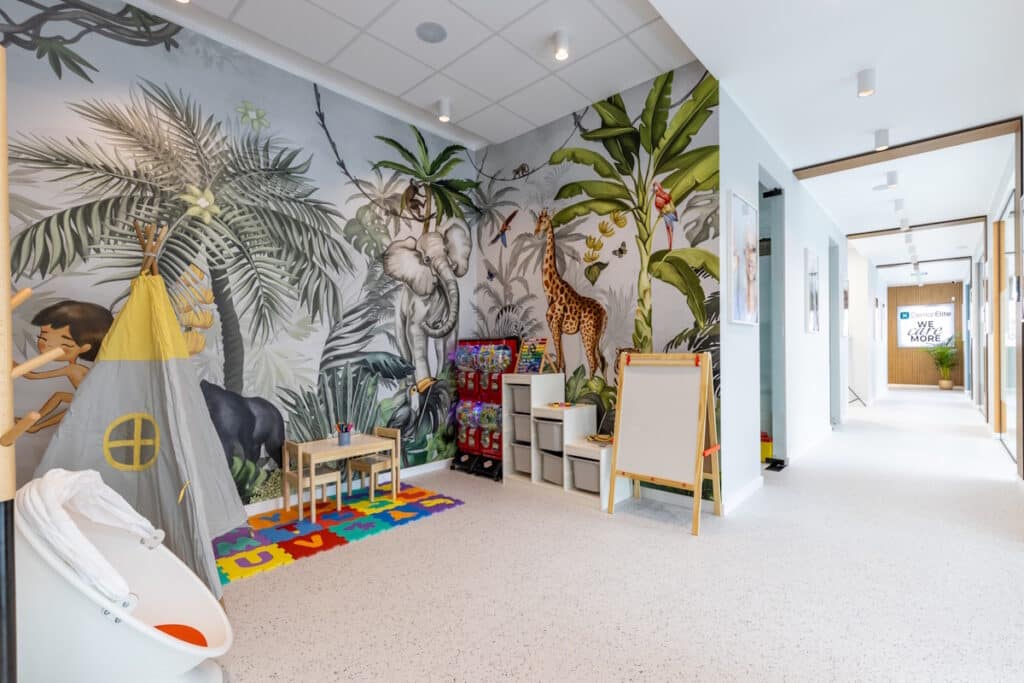 Zonă de joacă pentru copii în clinica Dental Elite, amenajată cu decoruri colorate și mobilier adaptat celor mici