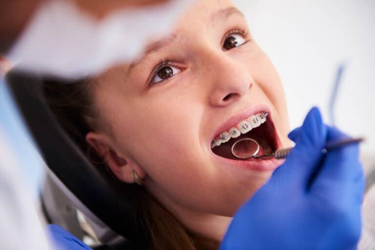 Fetita cu aparat dentar, la control, la stomatolog