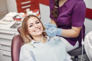 Femeie zambitoare, la dentist, dupa extractia de masea