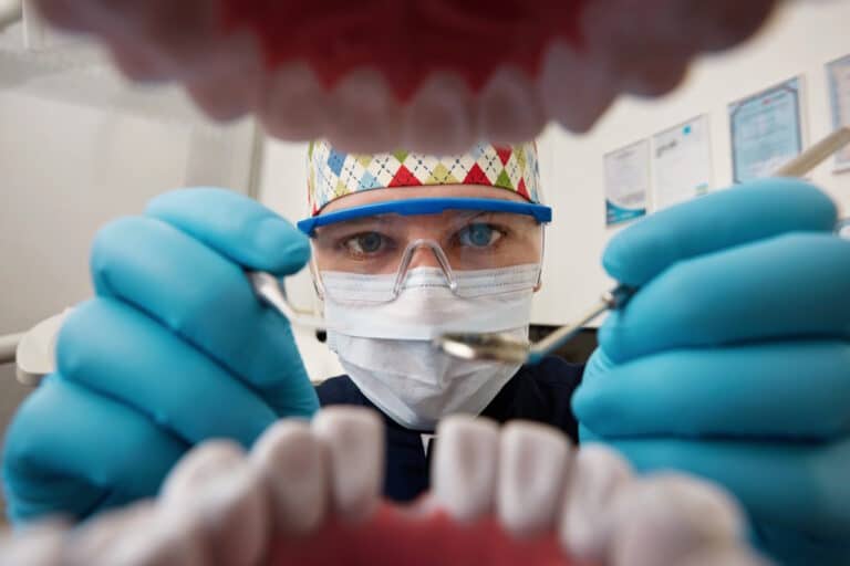 Medic dentist care consulta un pacient - vedere din cavitatea bucală