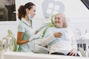 Pacienta cu diabet, zambind la dentist, dupa interventia de implant dentar