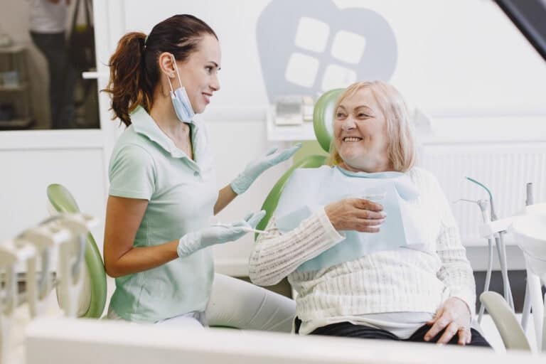 Pacienta cu diabet, zambind la dentist, dupa interventia de implant dentar