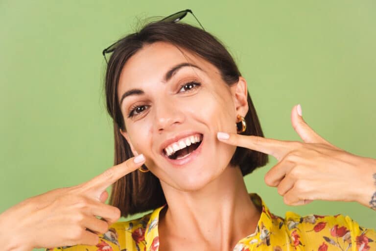 Femeie care zambeste cu coroane dentare rezistente
