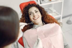 Femeie la dentist dupa montare cele mai bune coroane dentare