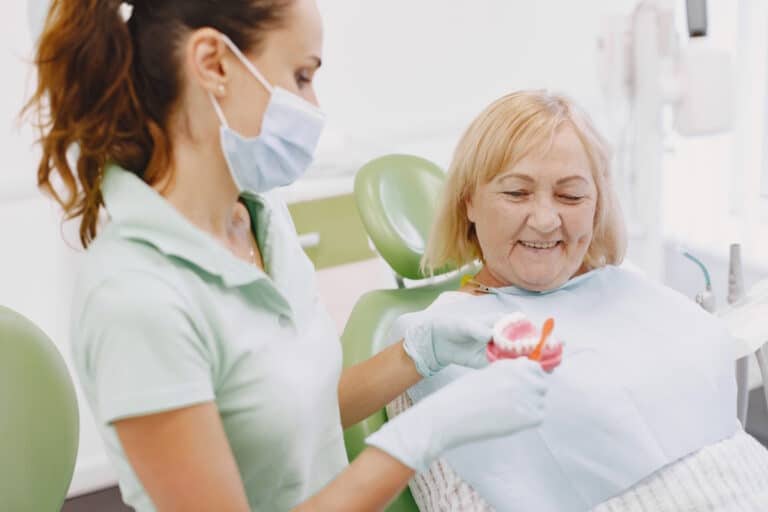 Medic stomatolog explicand pacientei igiena orala corecta dupa implant dentar